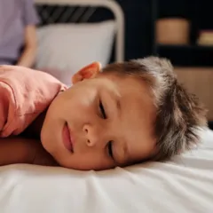 Kisfiú alszik az ágyában